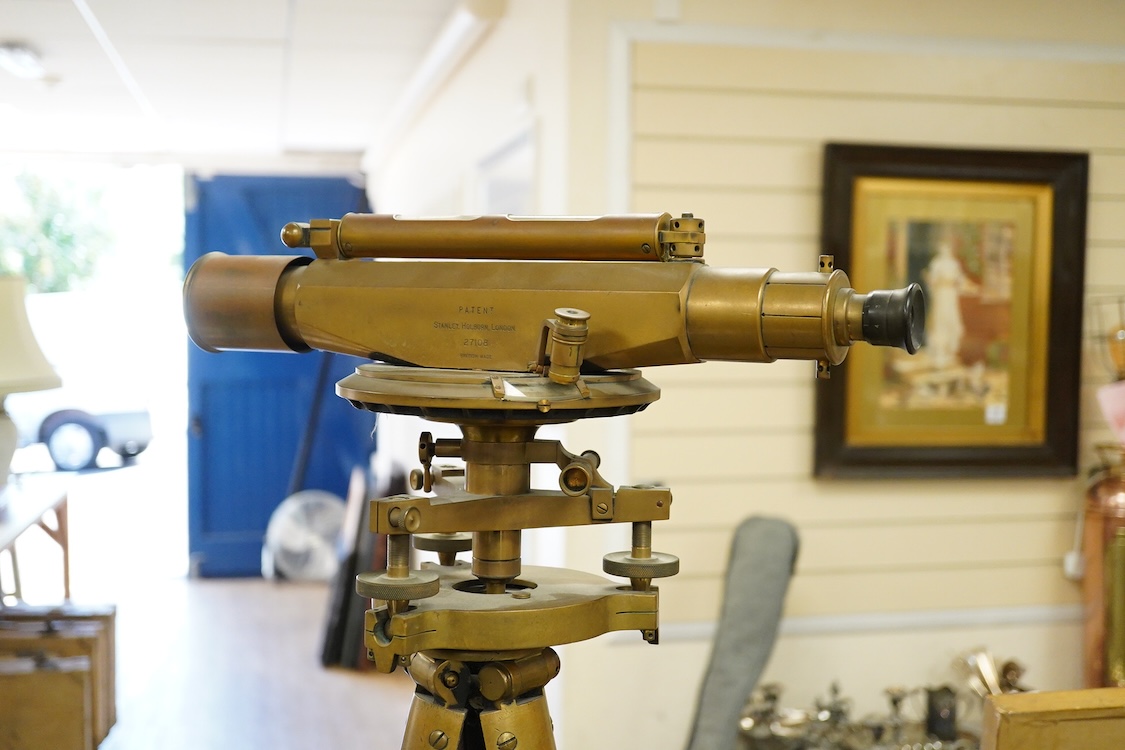 An early 20th century surveyor’s brass theodolite by Stanley, Holborn, London, serial number 27108, on original brass mounted tripod with oak legs, overall height 170cm